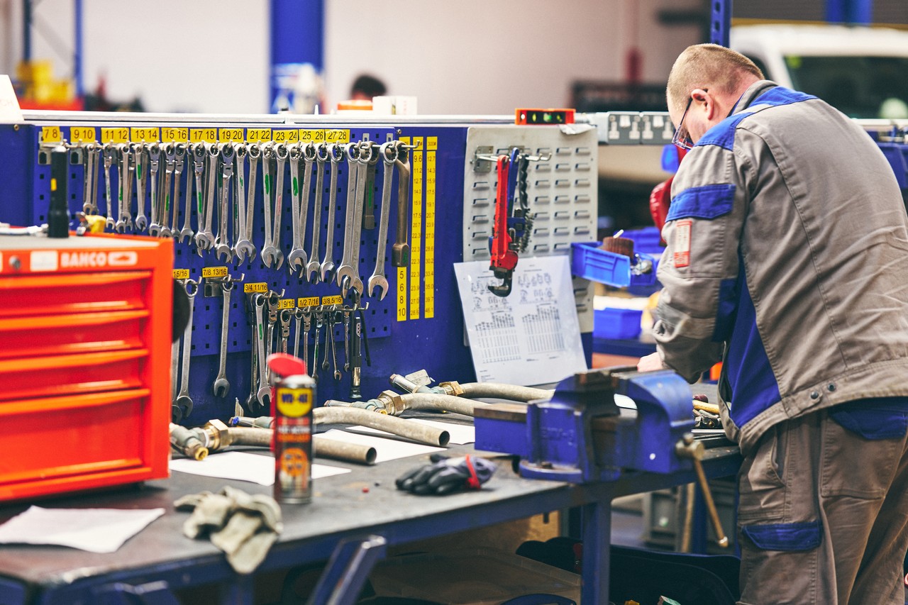 Workshop with organised tool racks and a technician working.